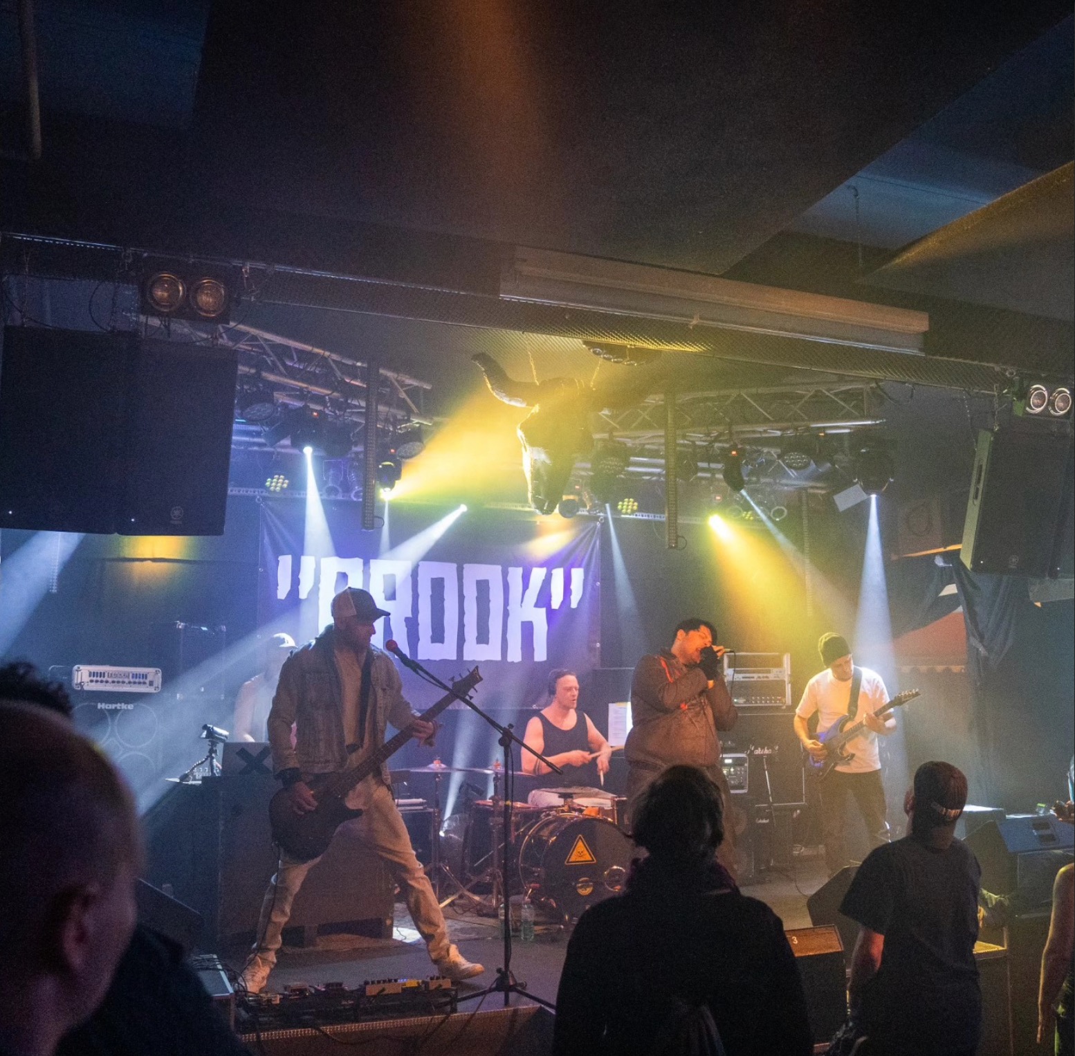 Crowd watching BROOK perform under a disco ball inside a small venue